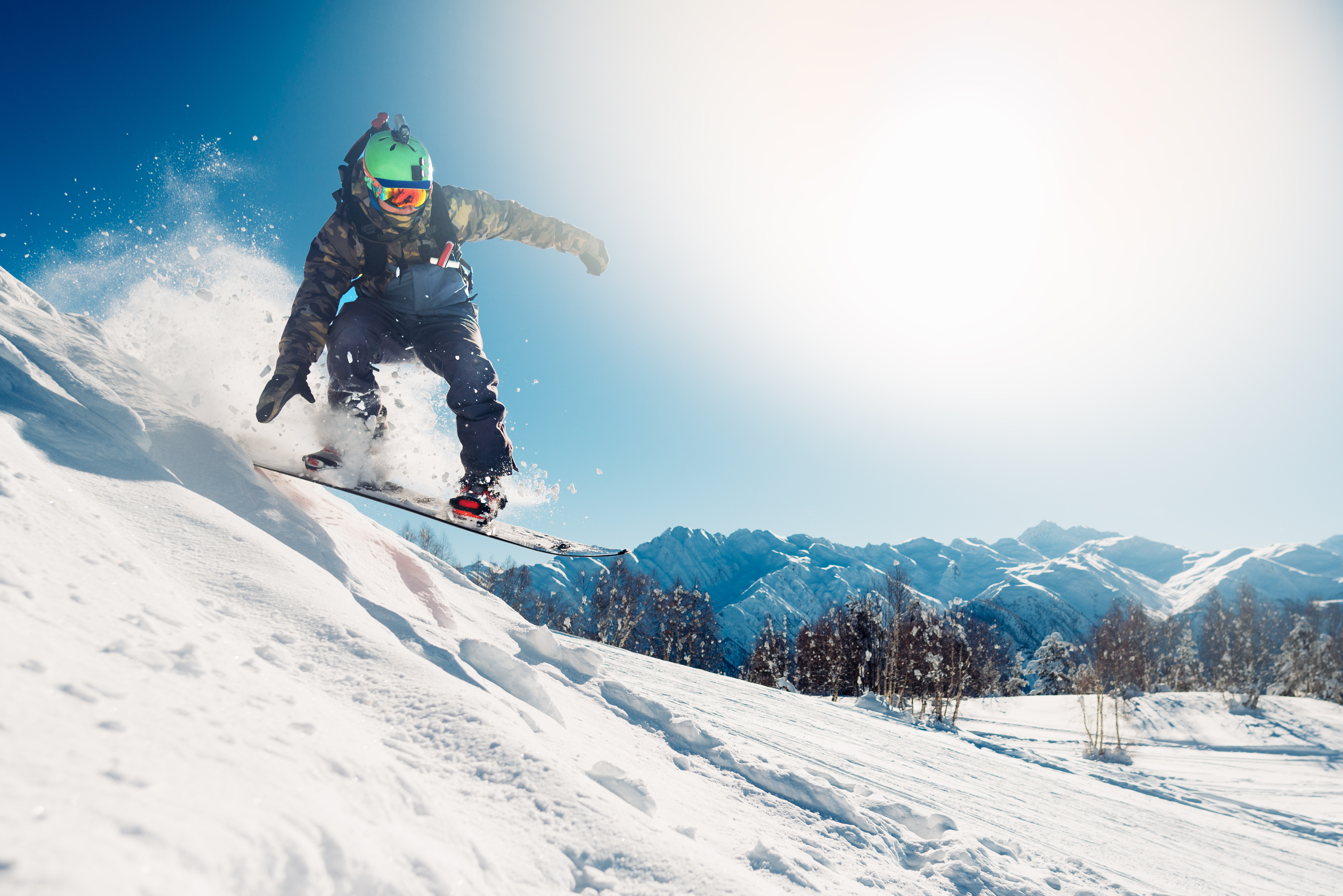 CEECOACH PLUS_Eine Person auf dem Snowboard_fährt die Piste hinunter CEECOACH PLUS_Eine Person auf dem Snowboard_fährt die Piste hinunter_klarer Himmel