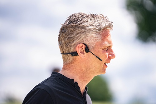 Mann trägt OpenComm2 Headset von Shokz_Seitenprofil. Mann trägt OpenComm2 Headset von Shokz_Seitenprofil.