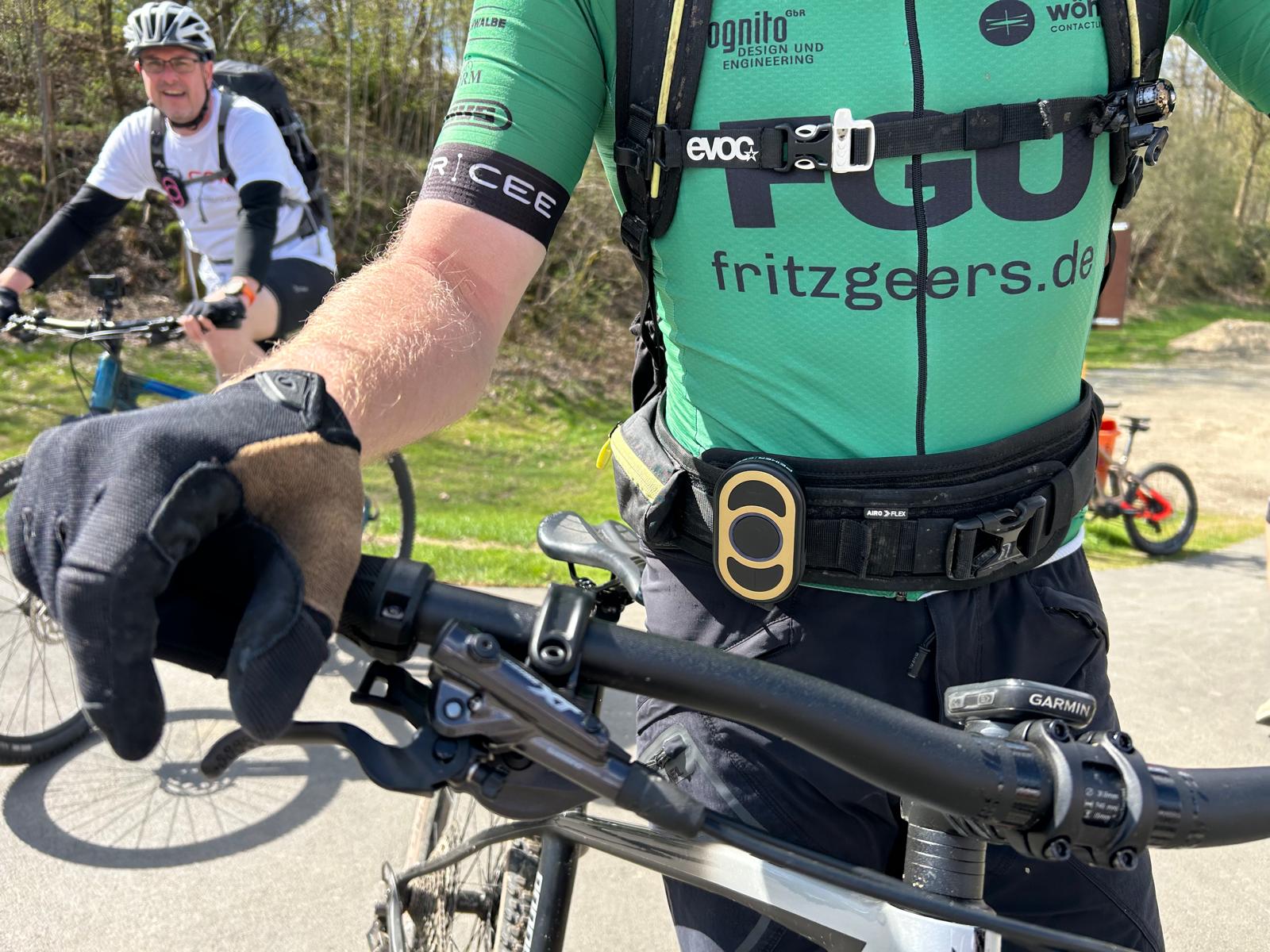 A mountain biker with professional equipment_golden CEECOACH PLUS strapped around his waist A mountain biker with professional gear and a golden CEECOACH PLUS strapped around their waist