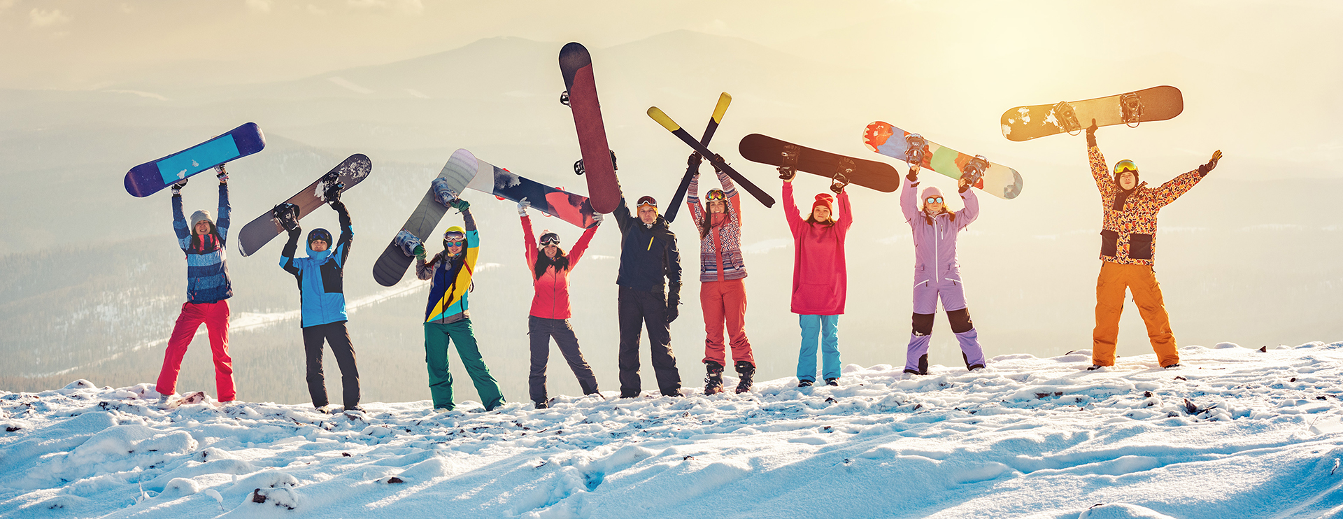 Acht Kinder stehen im Schnee und halten Snowboards über dem Kopf_sonniger Wintertag CEECOACH PLUS_Acht Kinder stehen im Schnee und halten Snowboards über dem Kopf, sonniger WintertagAcht Kinder stehen im Schnee und halten Snowboards über dem Kopf, sonniger Wintertag
