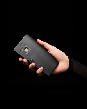 Die In&Box-Steuereinheit von In&motion. Hand hält die In&Box-Steuereinheit von In&motion_schwarzer Hintergrund.