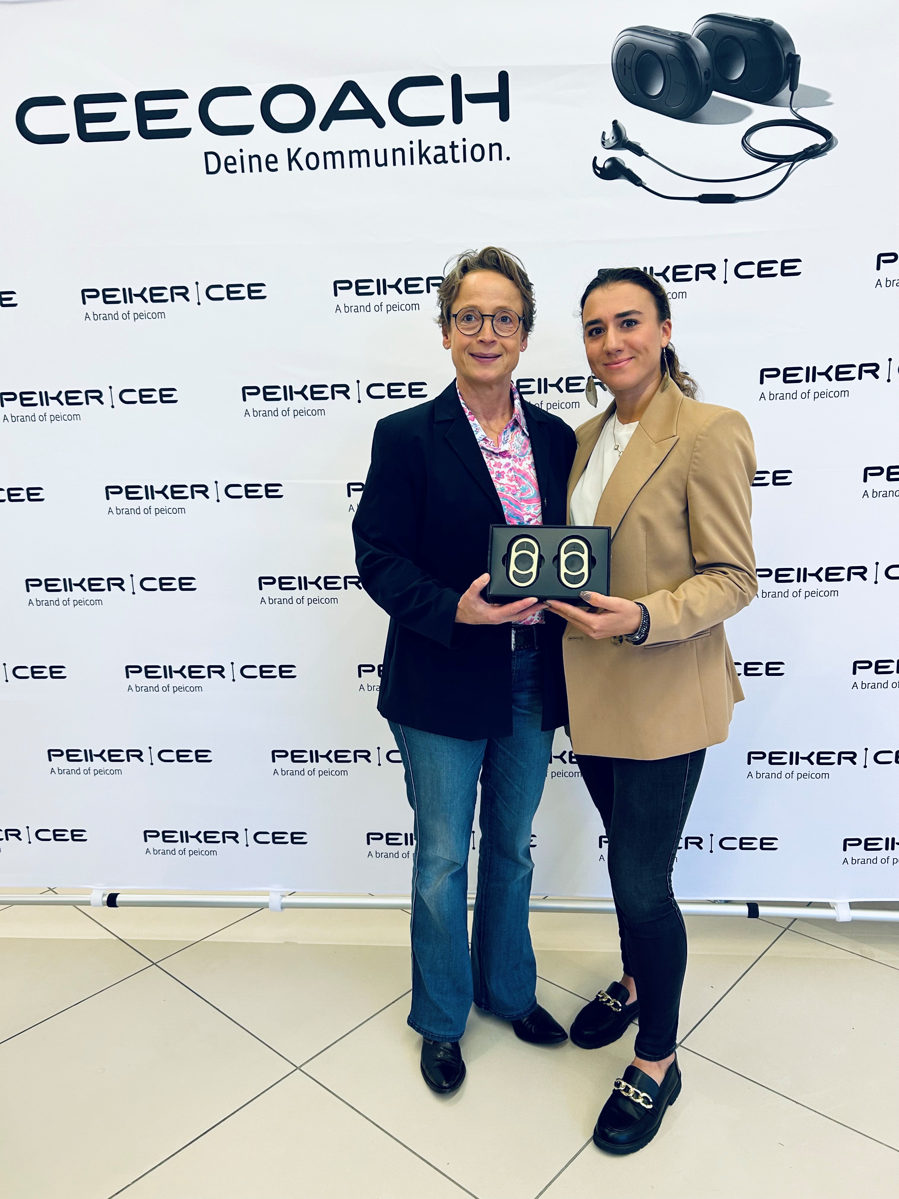 Isabell Werth_Carina Peiker halten zwei goldene CEECOACH PLUS Geräte in den Händen. Isabell Werth und Carina Peiker halten zwei goldene CEECOACH PLUS Geräte in den Händen.