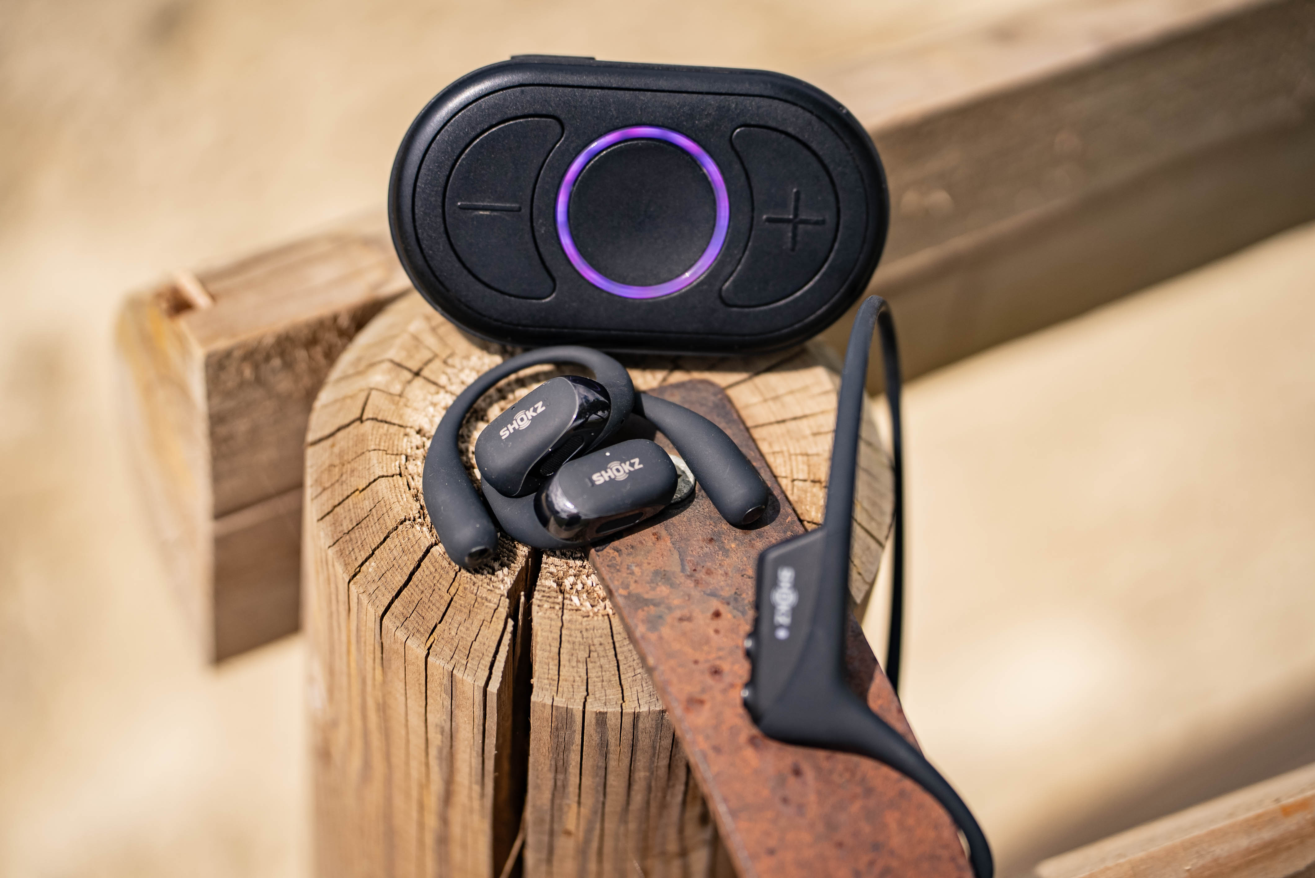Shokz OpenRun headphones and CEECOACH PLUS on wooden beams.